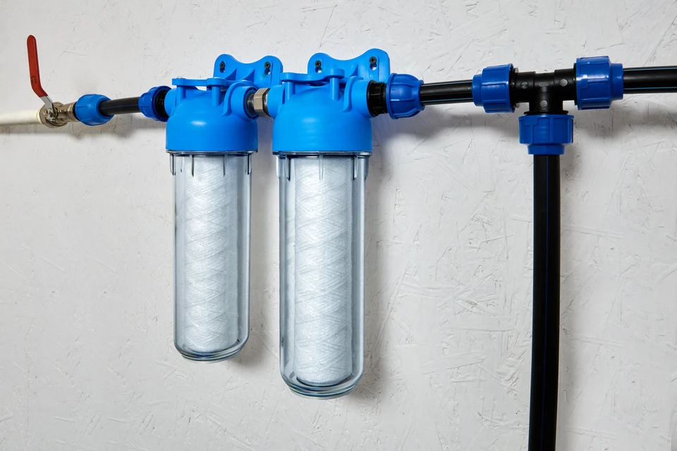 Intérieur technique avec système de filtration d'eau domestique monté sur mur blanc