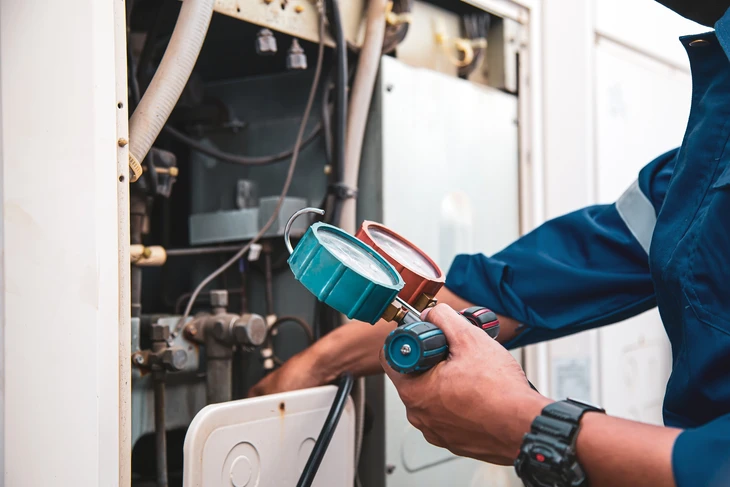 Technicien en climatisation travaillant sur une unité extérieure de climatisation