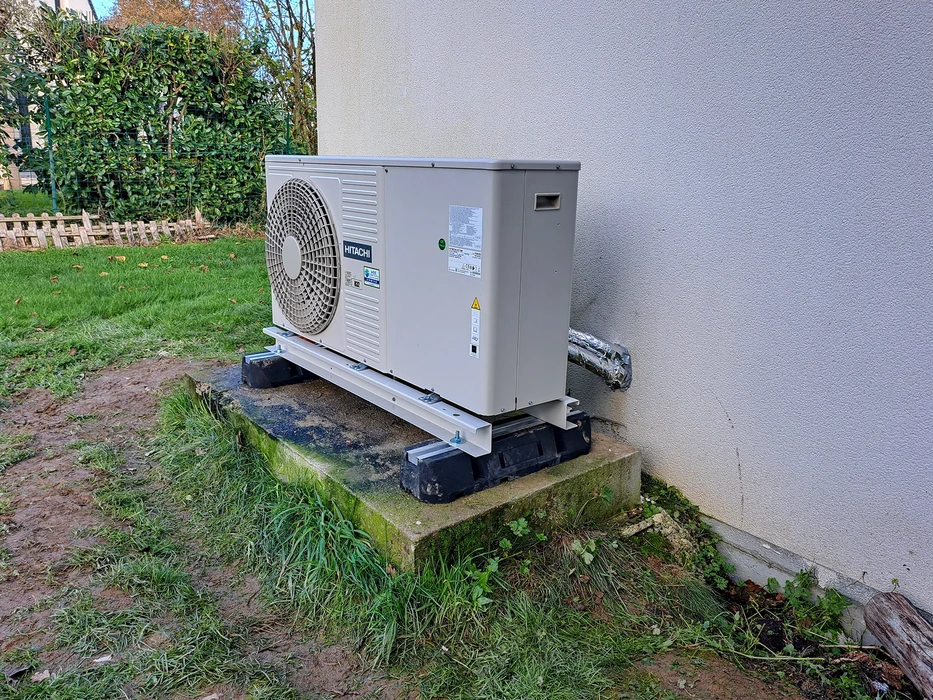 Unité extérieure de pompe à chaleur air/eau Hitachi, installée en extérieur sur dalle béton avec silent-blocs anti-vibratoires et châssis métallique