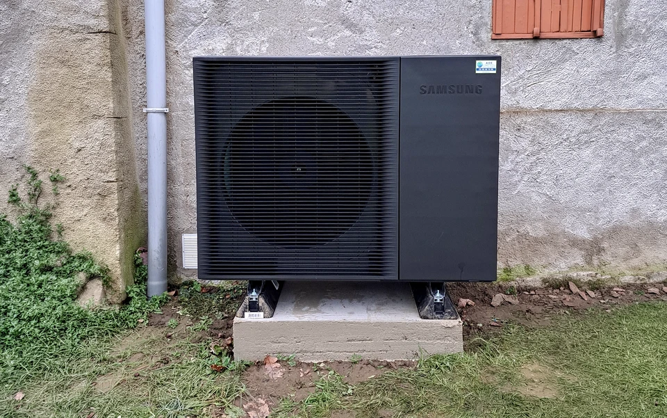 Une pompe &agrave; chaleur &agrave; air moderne install&eacute;e dans la chaudi&egrave;re de la maison, des tuyaux en plastique visible et des valves