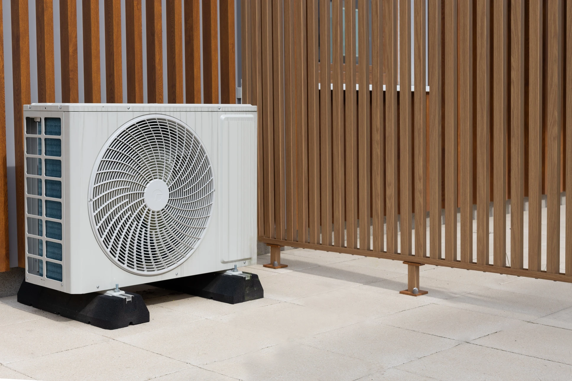 Extérieur résidentiel avec unité de climatisation installée sur dalle béton